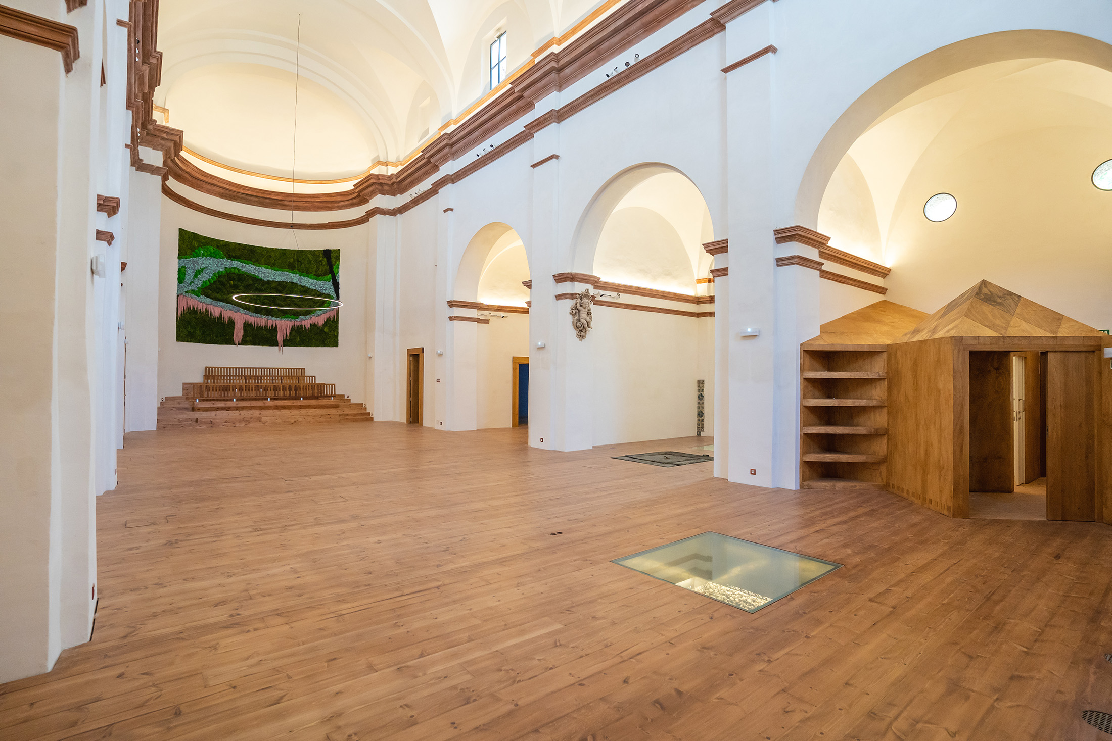 Perspectiva del interior mostrando la estructura de madera cúbica en la zona de acceso